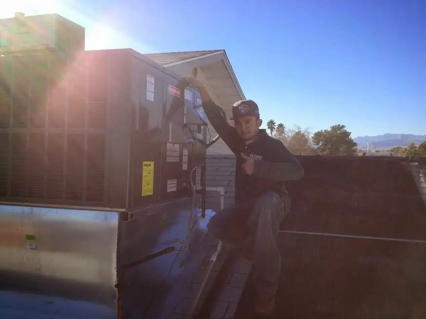 HVAC technician performing Air Duct Cleaning on a rooftop unit in Bogalusa